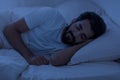 Healthy Sleeping. Portrait of young indian man lying in bed in night Royalty Free Stock Photo