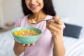 Healthy slimming diet concept. Cropped view of Indian lady with bowl of cereal at home, closeup