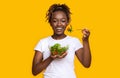 Healthy black girl eating fresh salad over yellow Royalty Free Stock Photo