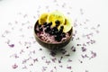 Healthy smoothie bowl breakfast in coconut plate with lilac flowers