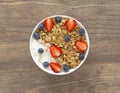 Healthy smoothie bowl with granola, yogurt, strawberry and fresh blueberries on wooden background. Breakfast smoothie bowl Royalty Free Stock Photo