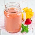 Healthy smoothie with strawberry, mango and banana in glass jars, square format Royalty Free Stock Photo