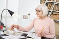 Satisfied mature woman eating during study
