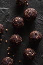 Healthy snack concept. Homemade vegan energy balls with raw buckwheat and dried fruits on black background top view low key Royalty Free Stock Photo