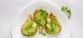 Healthy snack concept. Toasts with avocado, shrimps and arugula on white background. Top view, flat lay