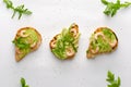 Healthy snack concept. Toasts with avocado, shrimps and arugula on white background. Top view, flat lay