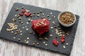 Healthy snack cracker or biscuit with seeds and beetroot top view on a stone plate with oat flakes on wooden background, healthy Royalty Free Stock Photo