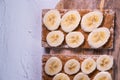 Healthy snack with cripsbread, peanut butter and banana`s slices on a wooden table. Top view. Close up view