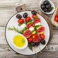 Healthy snack: mouth-watering kebabs on a picnic with tomatoes, mozzarella, salami, black olives, Basil, tortellini Royalty Free Stock Photo