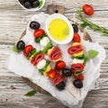 Healthy snack: mouth-watering kebabs on a picnic with tomatoes, mozzarella, salami, black olives, Basil, tortellini Royalty Free Stock Photo