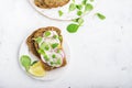 Healthy snack: slice grain bread with ricotta, green peas, radishes, lemon zest and juice. Top view