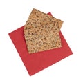 Healthy snack, wholemeal, wholewheat crackers with sunflower, linseed and sesame seeds. On red paper serviette, napkin