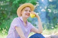 Healthy snack. Woman straw hat sit meadow hold apple fruit. Healthy life is her choice. Girl at picnic in forest on Royalty Free Stock Photo