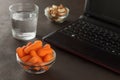 Healthy snacks for workplace lunch: baby carrots, almonds, cashew and glass of water. Royalty Free Stock Photo