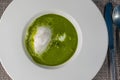 Healthy spinach soup served with egg on white plate, spring soup full of vitamins, product photography for restaurant