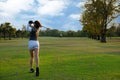 Healthy Sport. Asian Sporty woman golfer player doing golf swing tee off on the green evening time, she presumably does exercise. Royalty Free Stock Photo