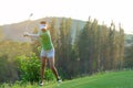 Healthy Sport. Asian Sporty woman golfer player doing golf swing tee off on the green evening time, she presumably does exercise. Royalty Free Stock Photo