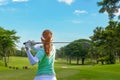 Healthy Sport. Asian Sporty woman golfer player doing golf swing tee off on the green evening time, she presumably does exercise.