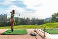 Healthy Sport. Asian sporty woman swing golf ball practice at golf driving range on evening on time for healthy sport.