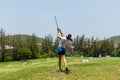 Healthy Sport. Asian sporty woman swing golf ball practice at golf driving range on evening on time for healthy sport.