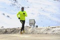 Healthy sport man running on asphalt road at snow mountains in trail runner hard workout in winter Royalty Free Stock Photo