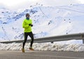Healthy sport man running on asphalt road at snow mountains in trail runner hard workout in winter Royalty Free Stock Photo