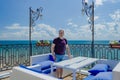 Healthy sports man aged standing in a cafe overlooking the sea and waiting for your order