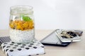 Healthi breacfast with chia placed on a notebook and tablet, phone and keys.