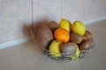 Healthy still life - variety of food. Bowl of different tropic fruits on table