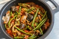 stir fry vegetables, green beans, mushrooms in an iron pot and wooden table Royalty Free Stock Photo