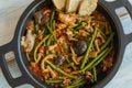 stir fry vegetables, green beans, mushrooms in an iron pot and wooden table Royalty Free Stock Photo