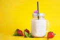 Healthy strawberry smoothie or drink yogurt in a mason a jar glass with berries and mint, over yellow background with copy space. Royalty Free Stock Photo