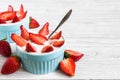 Healthy strawberry yogurt with fresh berries and spoon over white wooden table Royalty Free Stock Photo