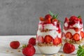 Healthy strawberry yogurt parfait with granola, mint and fresh berries in glasses on white wooden table Royalty Free Stock Photo