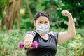 Healthy strong women exercise workout wear protective face mask for virus protection at public green park