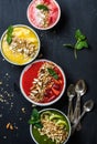 Healthy summer breakfast concept. Colorful fruit smoothie bowls with nuts and oat granola on black background Royalty Free Stock Photo