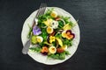 Healthy summer salad with quail eggs, avocado, pecans, wild rocket, red onion and edible viola flowers. Royalty Free Stock Photo