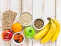 Healthy superfoods fiber source breakfast oats dried fruits apples bananas orange whole grain crackers milk thistle on white wood