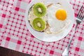 Healthy and tasty breakfast, quince juice, whole-grain bread sandwich with kiwi and egg on white plate, pink napkin