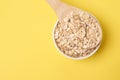 Healthy eating. Wooden spoon. Oat flakes. Yellow background