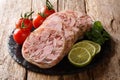 Healthy tasty food head cheese or brawn and fresh tomatoes, lime and cilantro closeup on a slate board. horizontal