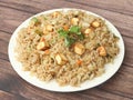 Healthy and tasty Paneer fried rice made of rice, mixed veggies and paneer, served in bowl over a rustic wooden background, Indo