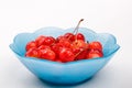 Ripe cherry berries with water droplets into blue plate on a white background Royalty Free Stock Photo