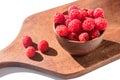Healthy tasty ripe raspberries in bulk on a wooden kitchen board.