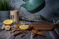 Healthy tea poured into transparent cup. Teapot, lemon, ginger, cardamom, heather bunch and glass jar Royalty Free Stock Photo