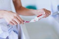 Healthy teeth are a daily habit. an unidentifiable woman putting toothpaste on her toothbrush at home. Royalty Free Stock Photo