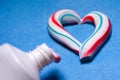 Healthy teeth. Hygiene of the oral cavity. Colored toothpaste from a tube. Pasta in the form of a heart Royalty Free Stock Photo