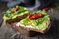 Healthy toast with avocado, goats cheese and arugula