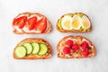 Healthy toast set with assorted proteins and fruits. Top view on a white marble background.