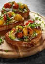 Healthy toasts with baked sweet cherry tomatoes and grilled zucchinin ribbons drizzled with balsamic vinegar